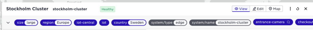 Interface showing metadata tags for the Stockholm Cluster, labeled as 'Healthy,' with tags for size, region, country, system type, and associated components like 'entrance-camera' and 'checkout'.